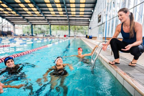 Swim coach with young swimmers at the poolside